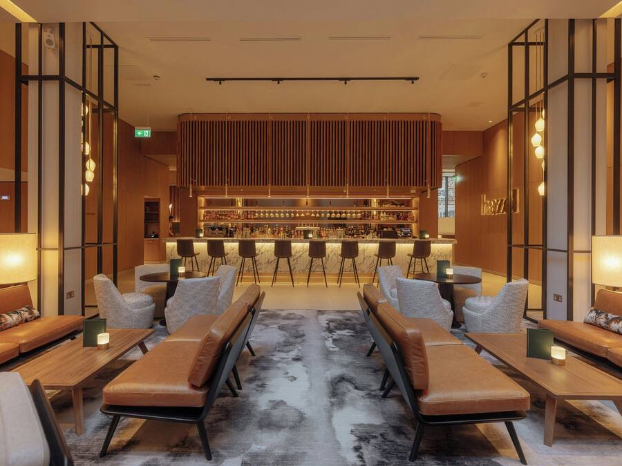 Un espace bar moderne, doté de sièges et d’un comptoir.