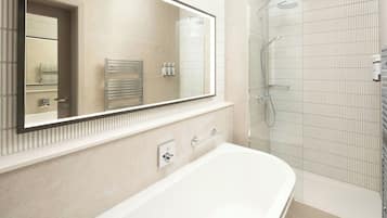 Un baño moderno con un espejo grande, una bañera, una ducha y un perchero para toallas.