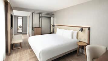 Une chambre d’hôtel moderne avec un grand lit, une table de chevet, une chaise et un téléviseur.