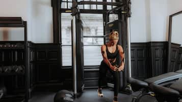 A gym with exercise equipment, a bench, and a weight ball.
