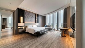 Une chambre d’hôtel moderne, dotée d’un grand lit, d’un bureau et d’une télévision.