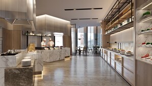 Une cuisine moderne avec un plan de travail en marbre, un chef en train de préparer un repas et un coin repas offrant une vue agréable.