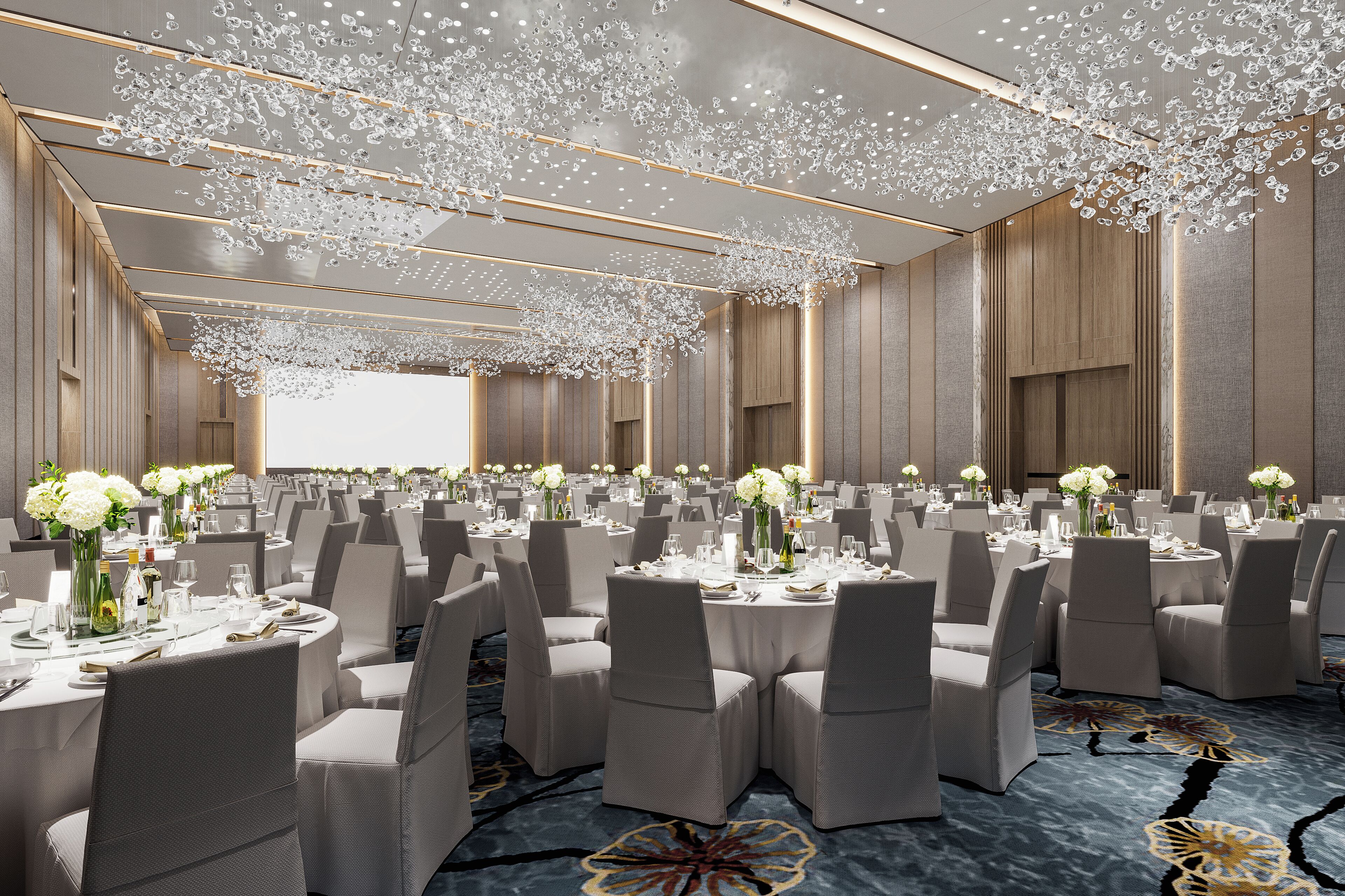 Un salón de banquetes con mesas redondas, sillas y centros de mesa florales.