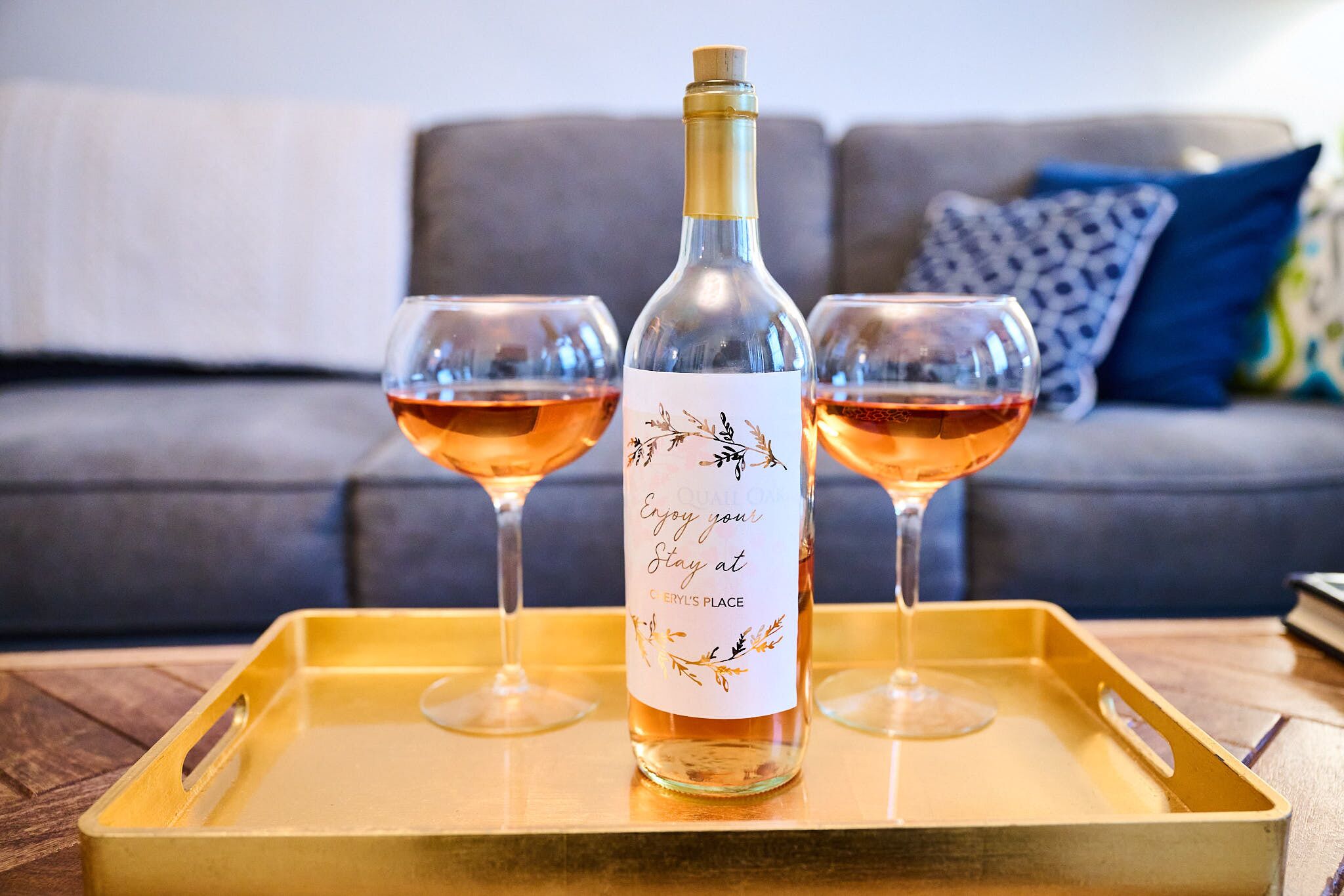 Une bouteille de vin sur un plateau, accompagnée de deux verres à vin.