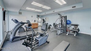 Ett gym med konditionsmaskiner, styrketräningsutrustning och en blå träningsboll.