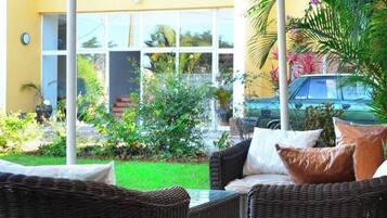 An outdoor seating area with wicker furniture and a covered section.
