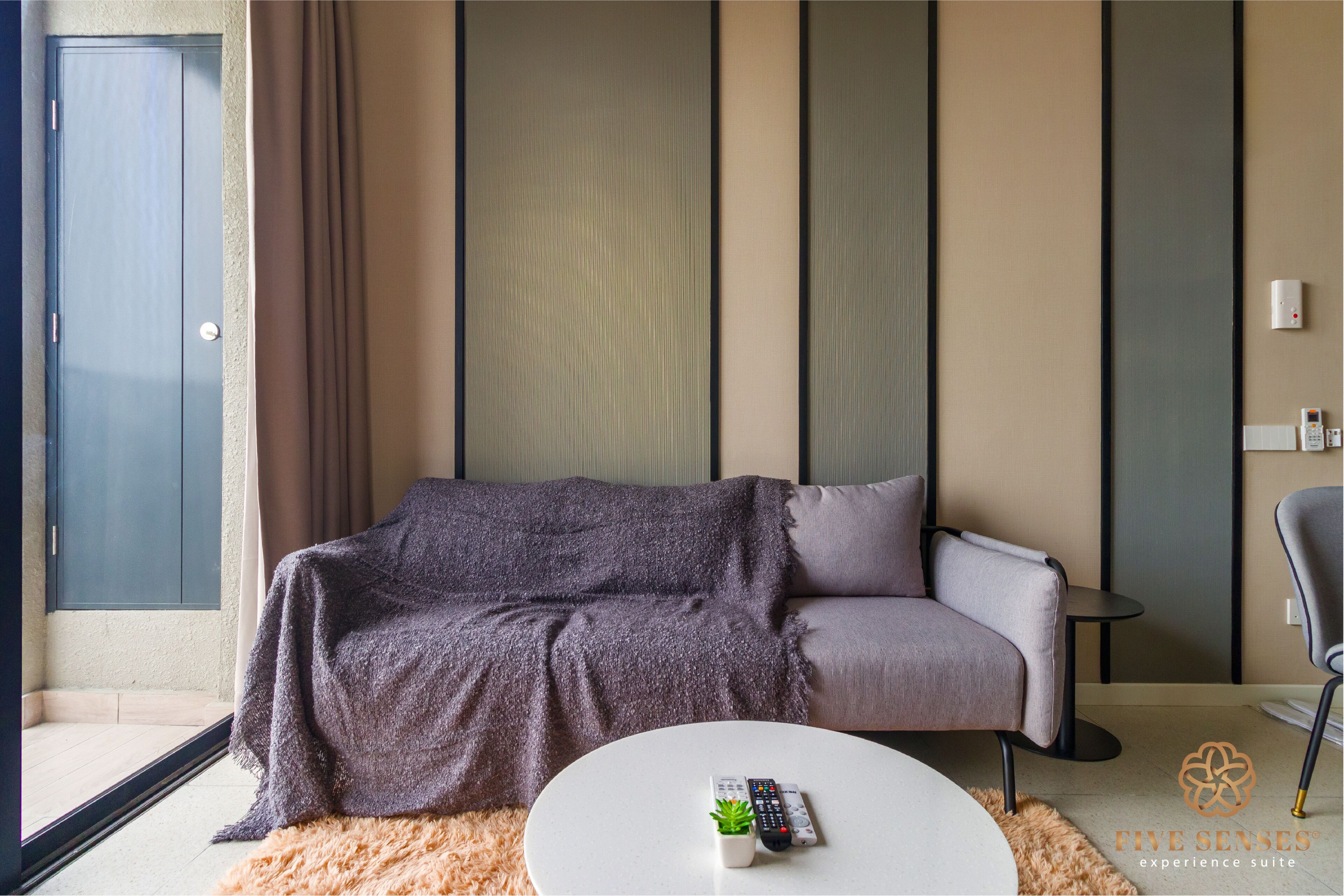 Un salon moderne avec un canapé gris, une table basse blanche et une télécommande.