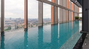 Una piscina al aire libre, sombrillas, sillones reclinables de piscina