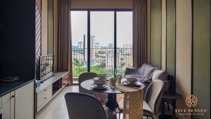 A dining area with a city view, a ceiling fan, and a table set for four.