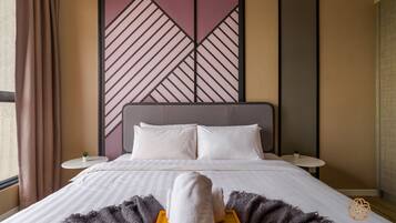 A hotel room with a bed, pillows, a bedside table, a small plant, and a decorative wall panel.