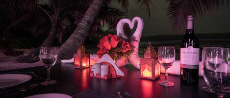 A table set for a romantic dinner with wine glasses, a bottle of Jacob's Creek Classic Shiraz Cabernet, and decorative lanterns.