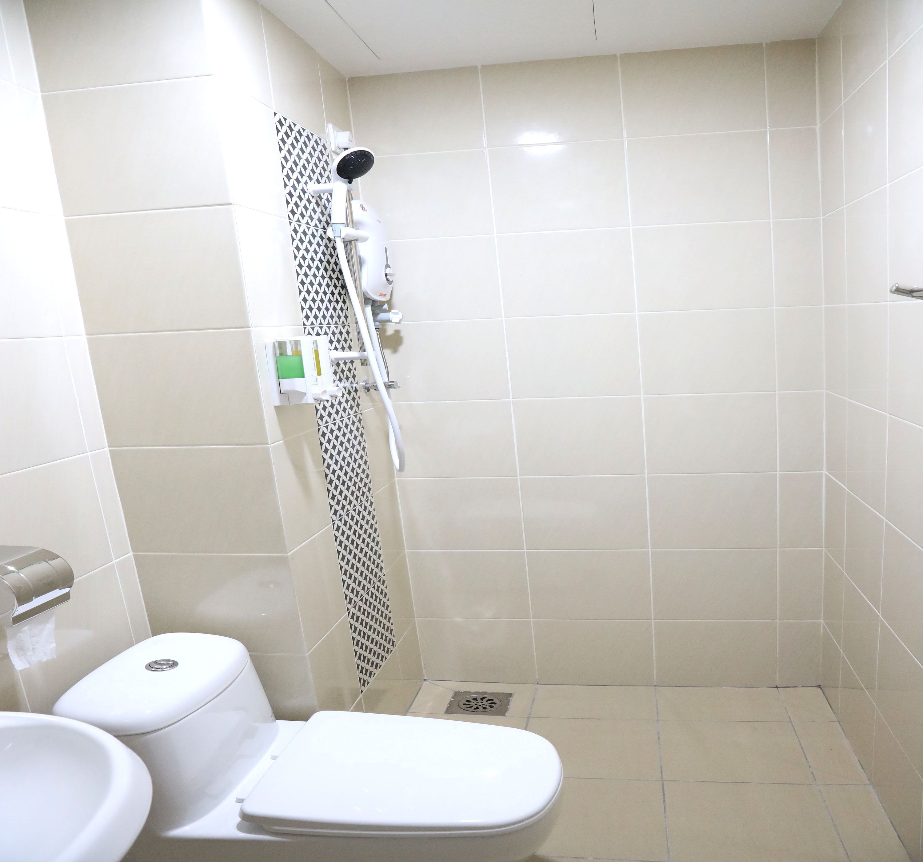 Un baño pequeño con azulejos, un inodoro, una ducha y un lavabo.
