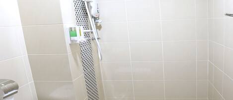 Un baño pequeño con azulejos, un inodoro, una ducha y un lavabo.