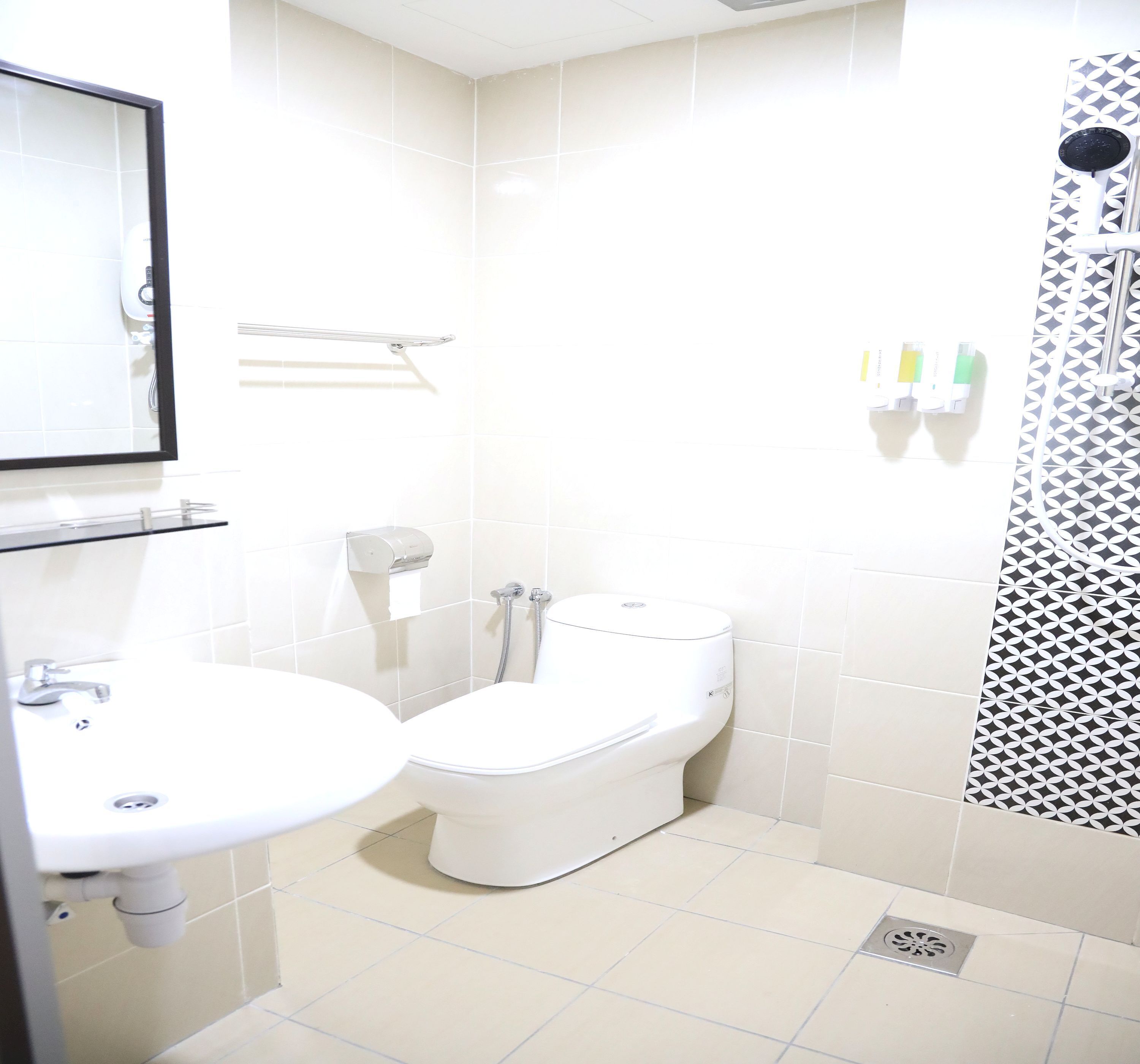 A bathroom with a toilet, sink, and shower.