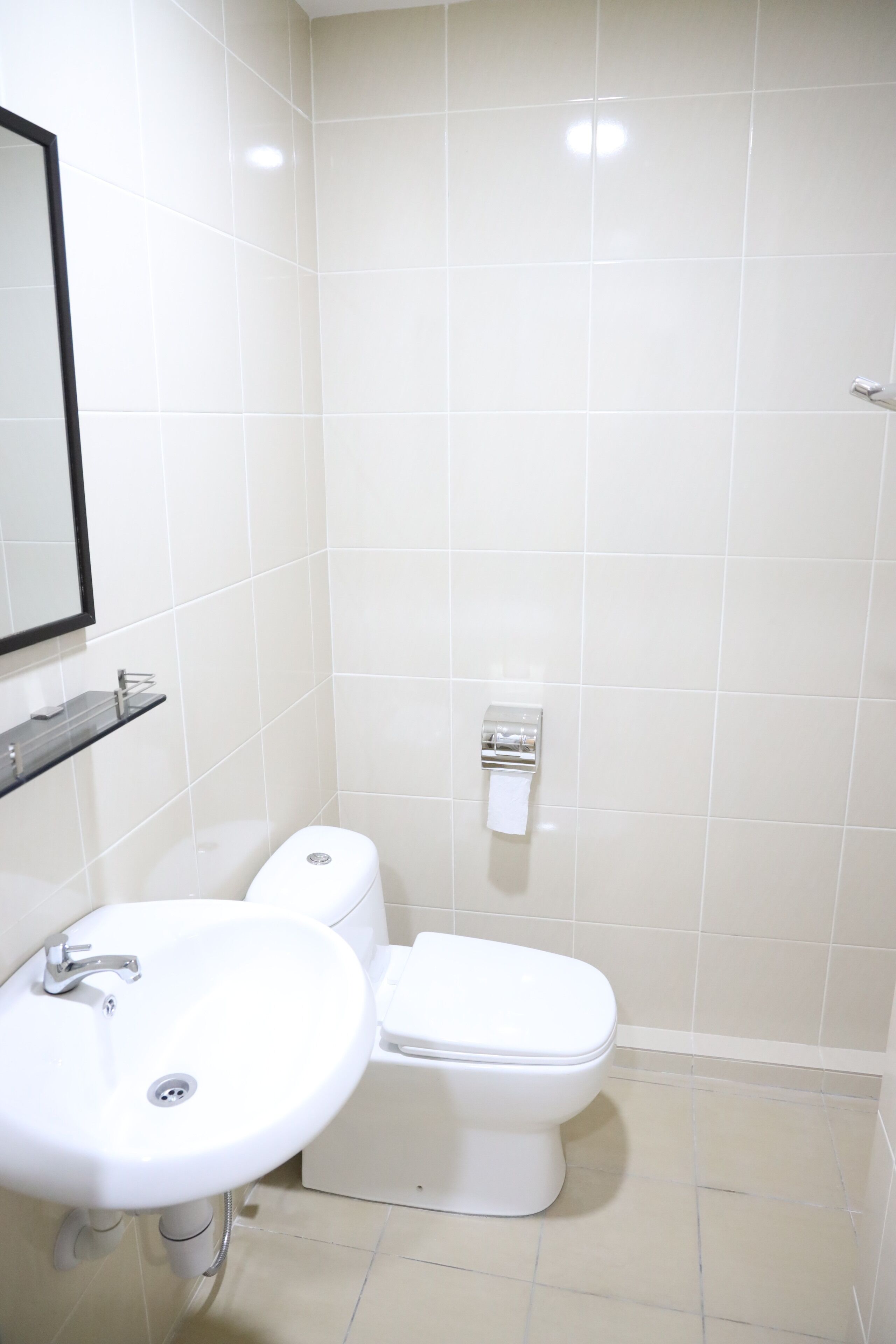 A bathroom with a white sink, toilet, and mirror.