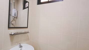 A bathroom with a white sink, a mirror, a towel rack, and a window.