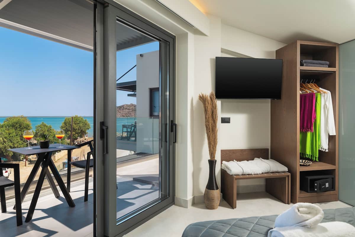 Une chambre d’hôtel moderne dotée d’un balcon, d’une télévision, d’une armoire et d’un lit.