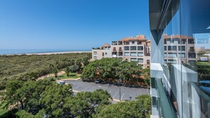 A high-rise building with multiple balconies overlooking a beach and a parking area. - Las Palmeras - Punta del Moral Beach PLHP28P11 (Punta del Moral)