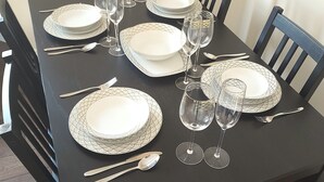 A dining table set with plates, cutlery, and wine glasses.