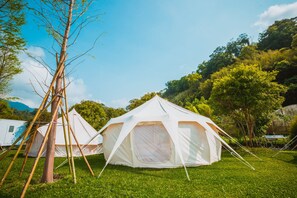 Two white tents set up on a grassy field with trees in the background. - kidsvillage (Dahu)