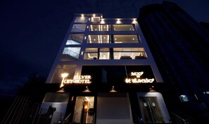 Un hotel moderno con señalización iluminada, varios pisos y una escalera visible.