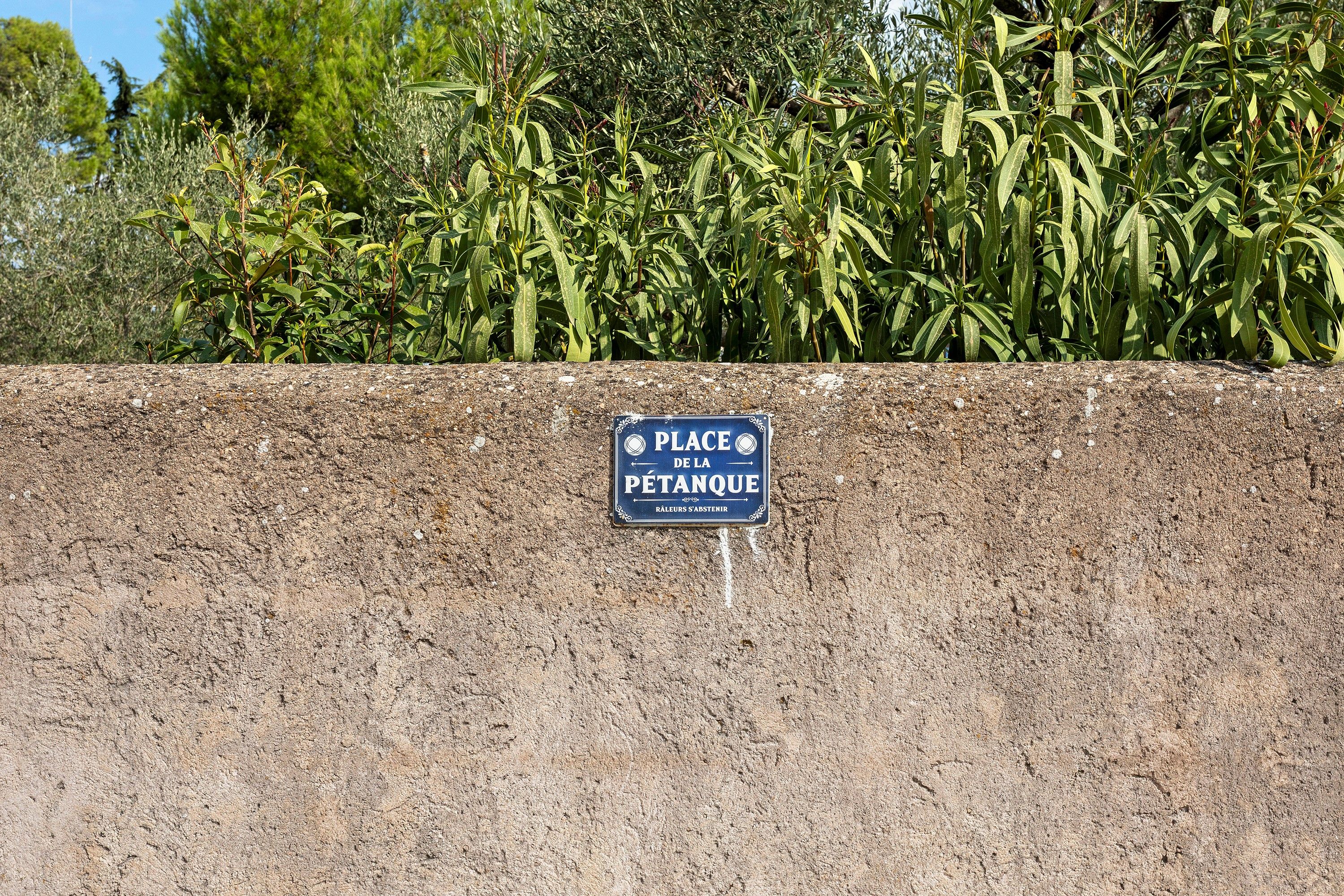 Schild an einer Betonwand, das einen Parkplatz kennzeichnet.