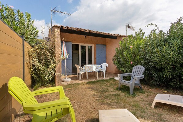 Une terrasse avec des meubles d’extérieur, une table et des chaises.