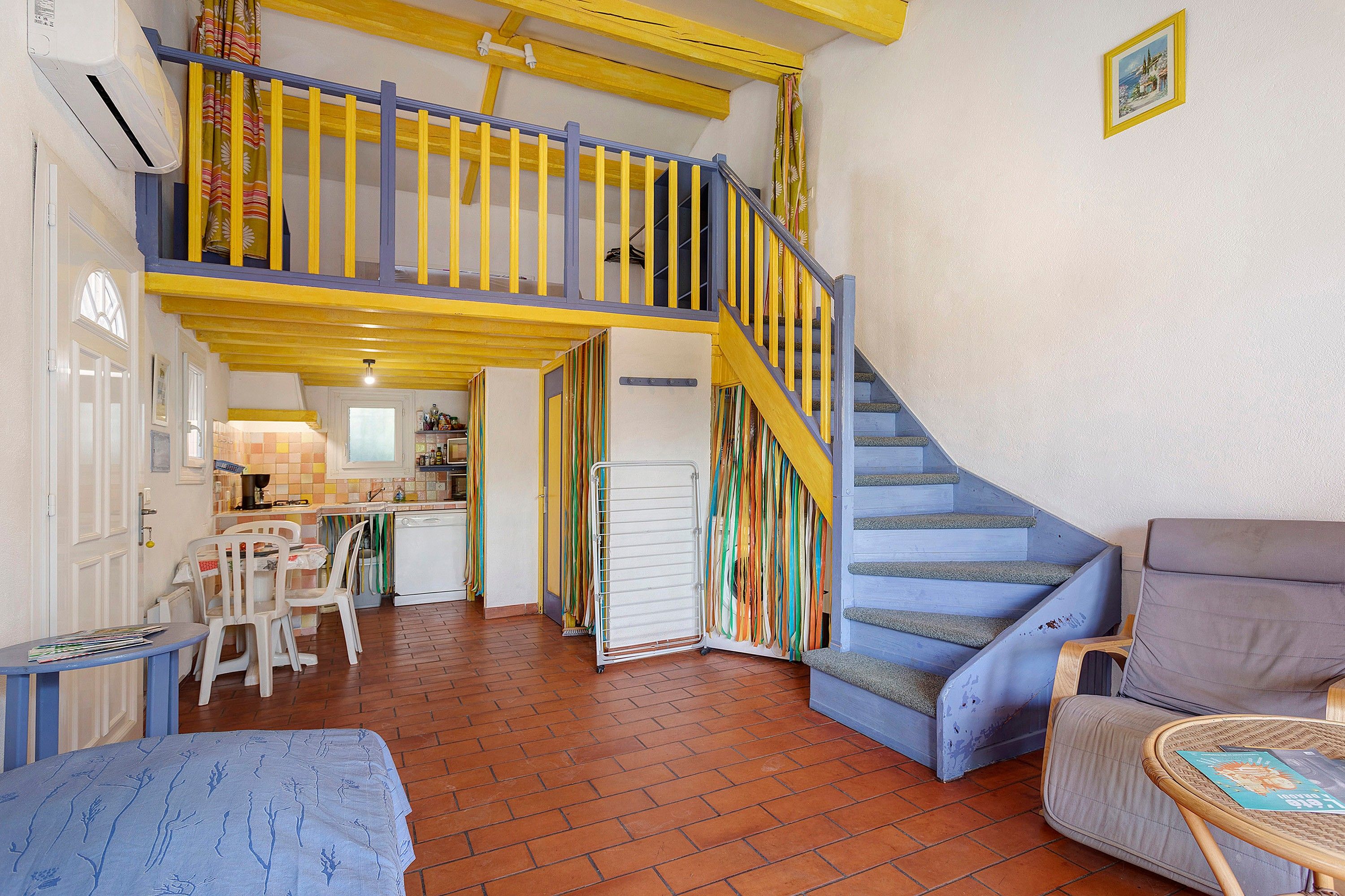 A multi-level interior with a staircase, a dining area, and a kitchen.