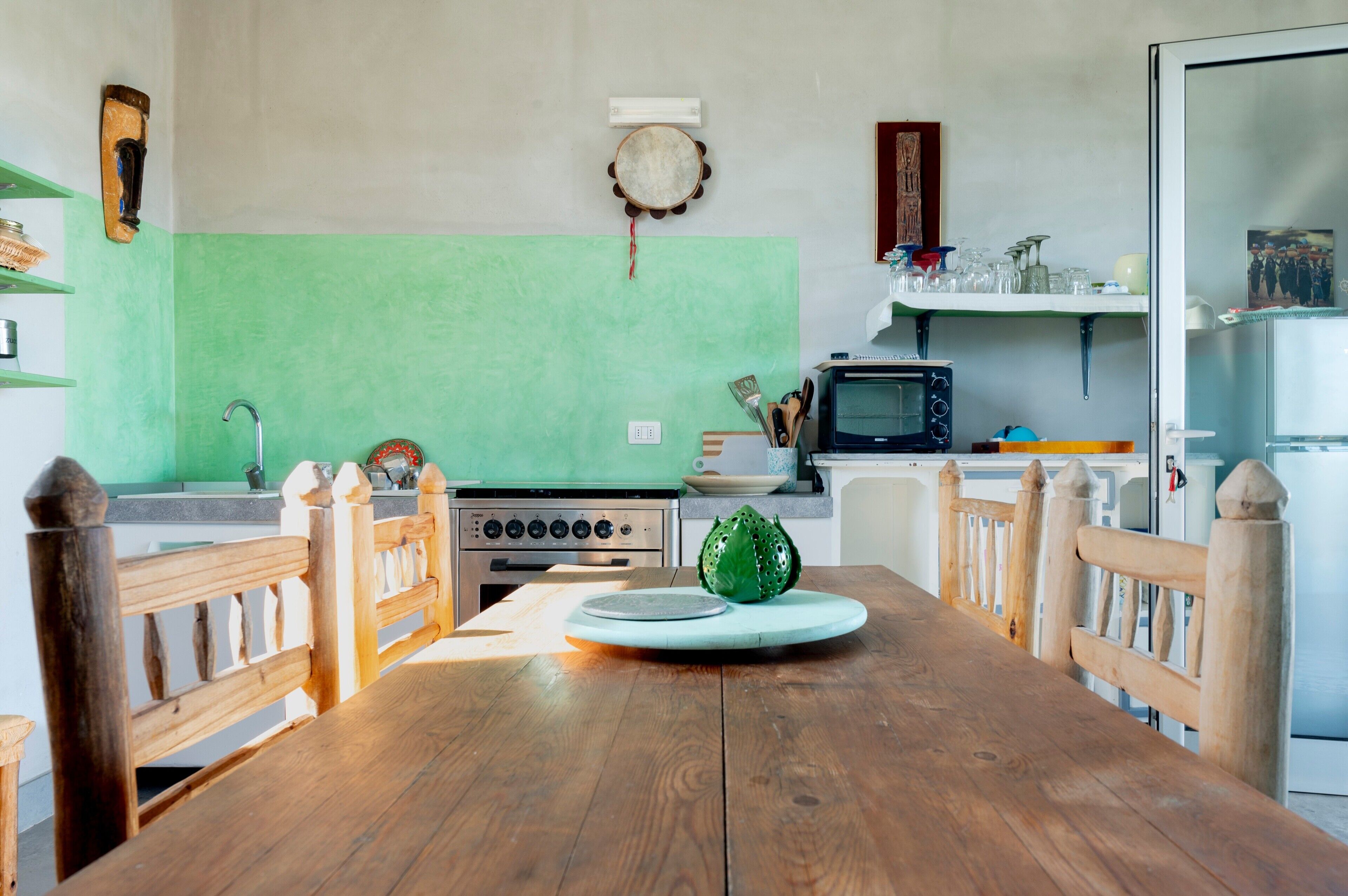 A kitchen with a wooden table, a stove, and a microwave.