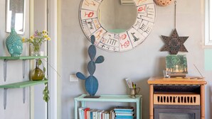 A room with a round mirror, a cactus sculpture, a bookshelf, and a star-shaped decoration. - Villa "Casa Romantica" with Shared Pool, 2 Private Terraces & Wi-Fi (Otranto)