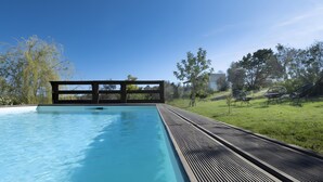 A swimming pool with a wooden deck, surrounded by trees and a grassy area with outdoor furniture. - Deluxe Double Room B&B Villa with Shared Pool, Private Terrace and Wi-Fi (Otranto)