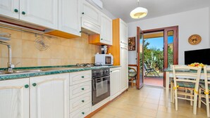 A kitchen with white cabinets, a microwave, and a dining area with a table and chairs.