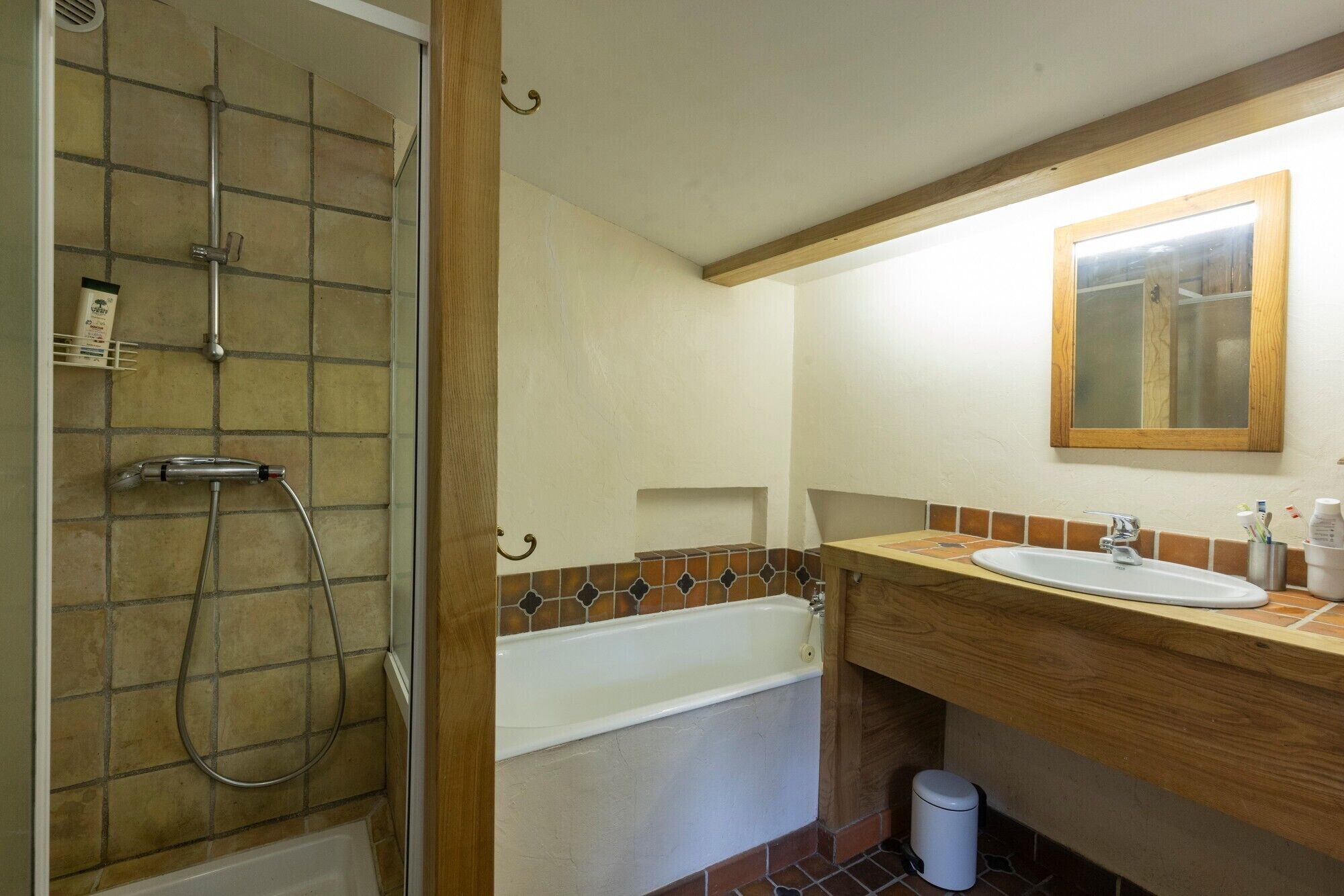 A bathroom with a shower, bathtub, sink, and mirror.