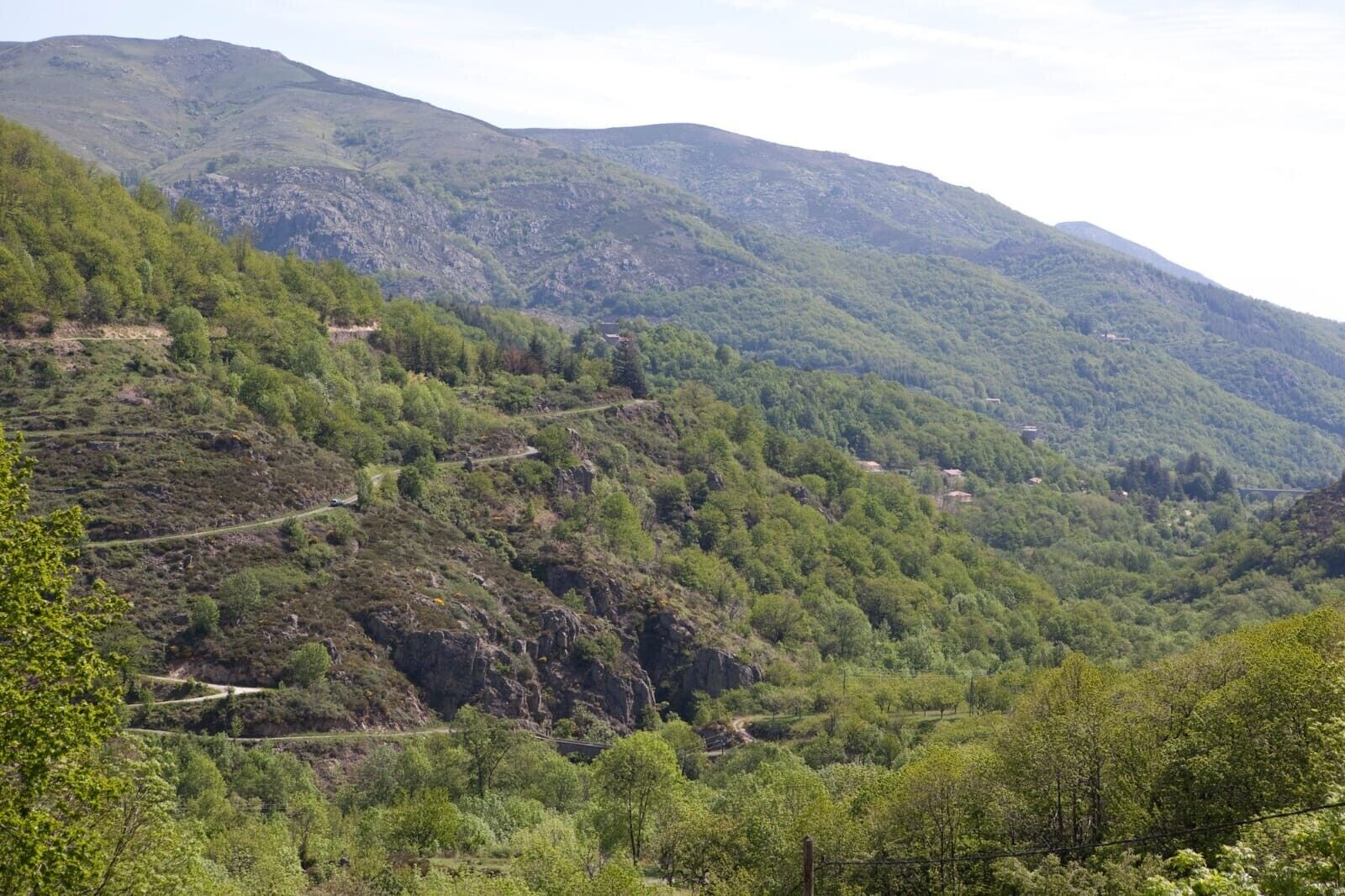 A mountainous landscape with terraced fields and a winding road.
