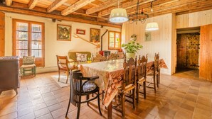 A wooden interior with a dining table, chairs, a sofa, and a staircase. - Holiday Home "Cal Barral" with Mountain View, Balcony & Wi-Fi (Ansovell)