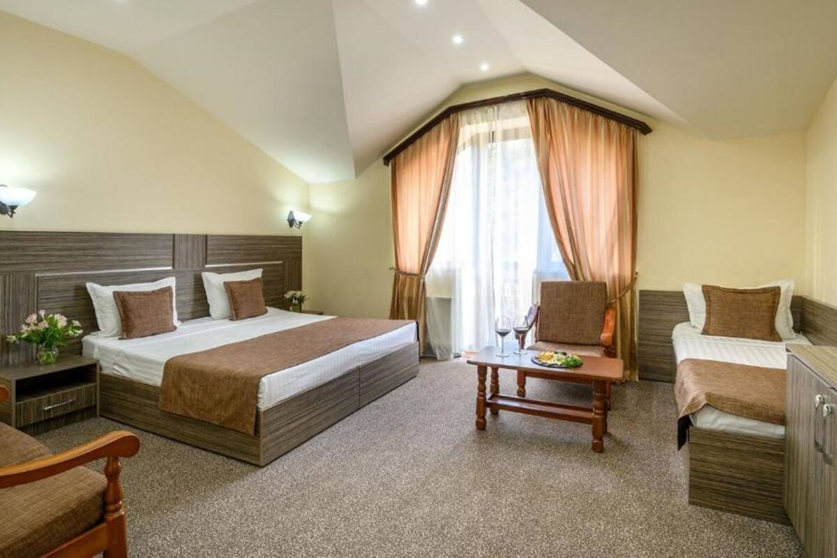 Habitació d'hotel amb dos llits, una taula petita amb un plat de menjar, una cadira i un armari.