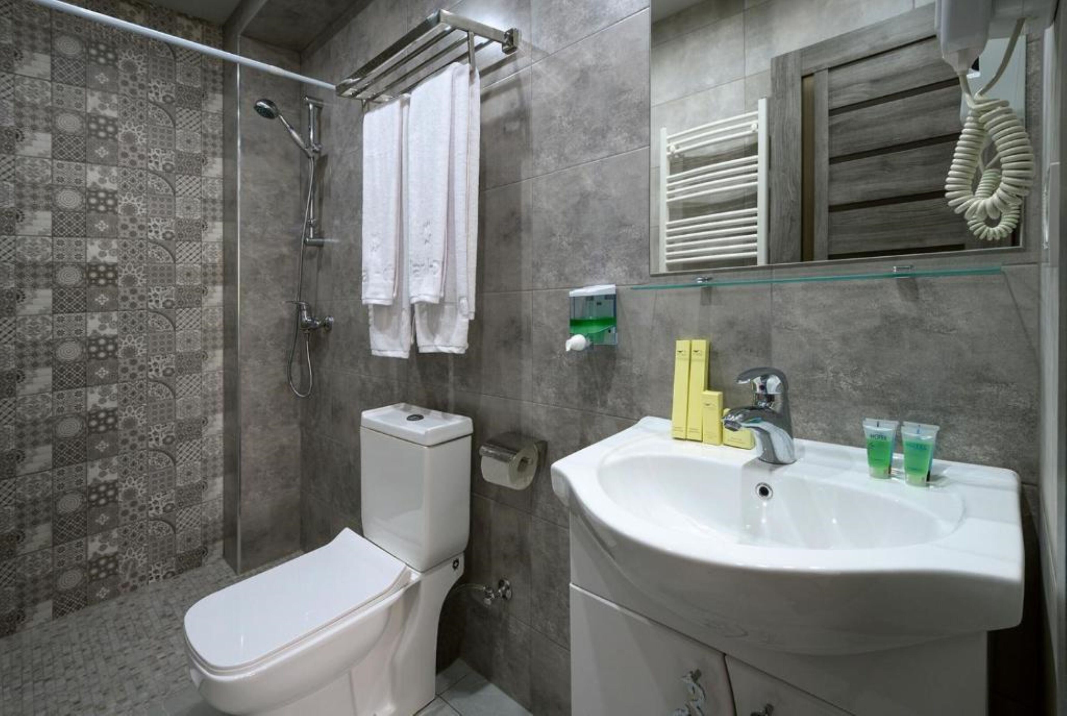 A bathroom with a shower, toilet, and sink.
