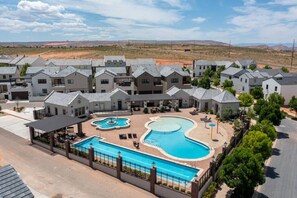 Um complexo residencial com várias casas, uma piscina central e uma área de pátio coberta.