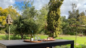 Une table de pique-nique en bois, avec des bancs, située dans un parc.