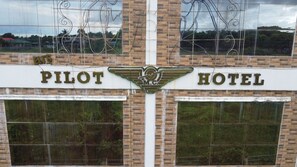 A building with a sign reading "PILOT HOTEL" and a logo with wings. - Pilot Hotel (Alaminos)