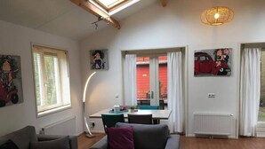 Ein modernes Wohnzimmer mit einer Couch, einem Esstisch und Bildern an den Wänden.