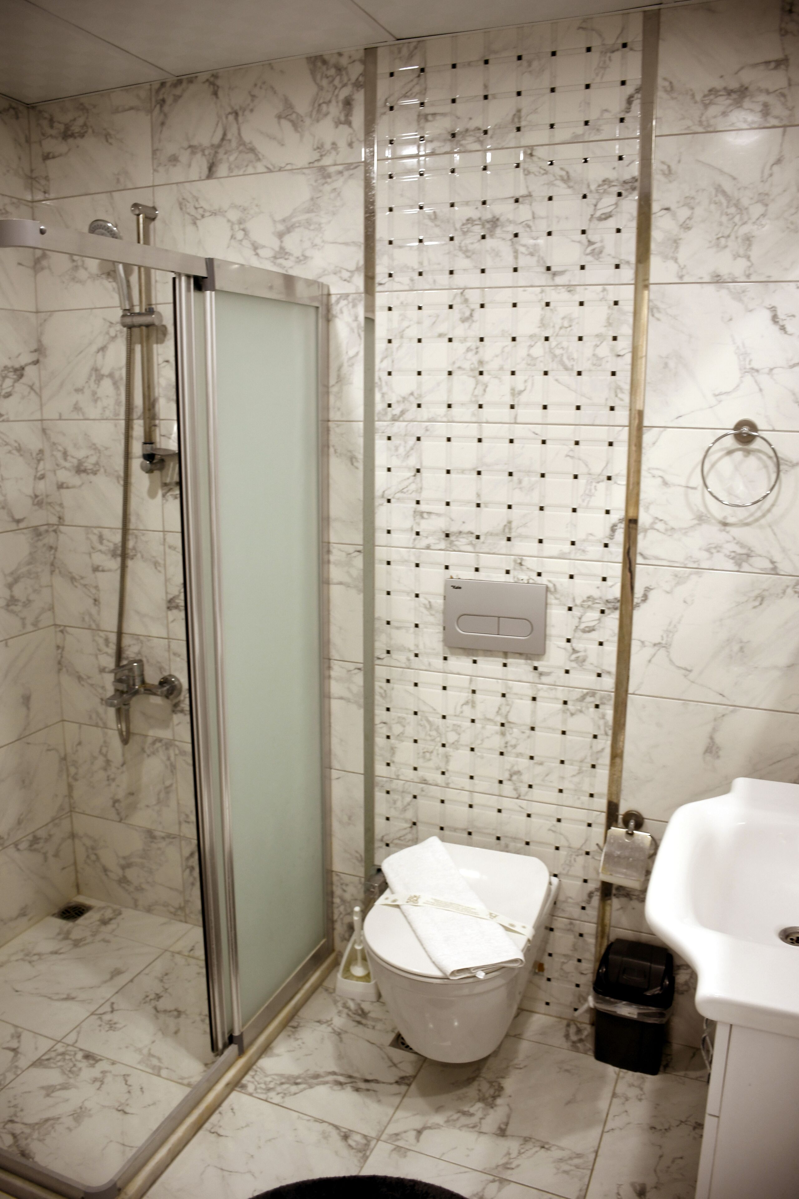 A bathroom with a shower, toilet, and sink.