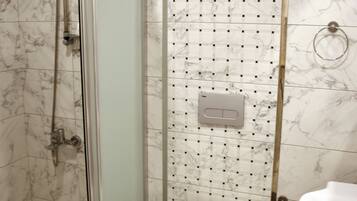 A bathroom with a shower, toilet, and sink.