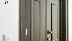 A closed door with a keyhole and a doorbell. - Colosseum Building - Apartment Gamma (Lisbon)