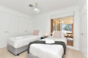 Habitación de hotel con dos camas, un ventanal grande y vistas al exterior.