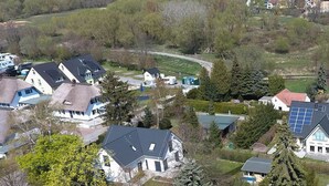 Un quartier résidentiel comprenant des maisons, une route et une étendue d’eau.