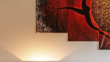 Habitación de hotel ordenada con cabecera de madera, mesita de noche con lámpara y cama con ropa blanca.