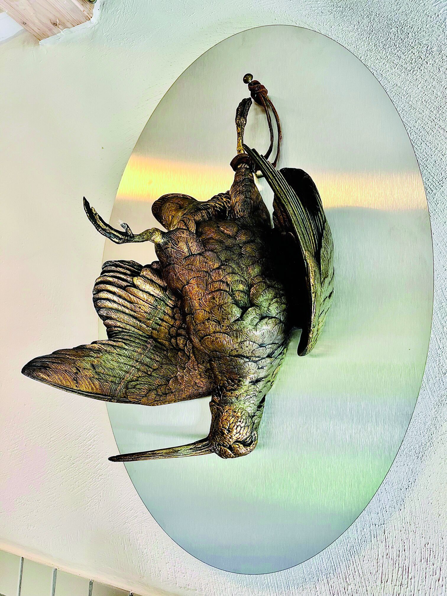 A wall-mounted sculpture of a bird with outstretched wings.