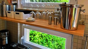 A kitchen with a wooden countertop, stainless steel appliances, and a window with a view of greenery. - Vacation between nature and design (Ribnitz-Damgarten)