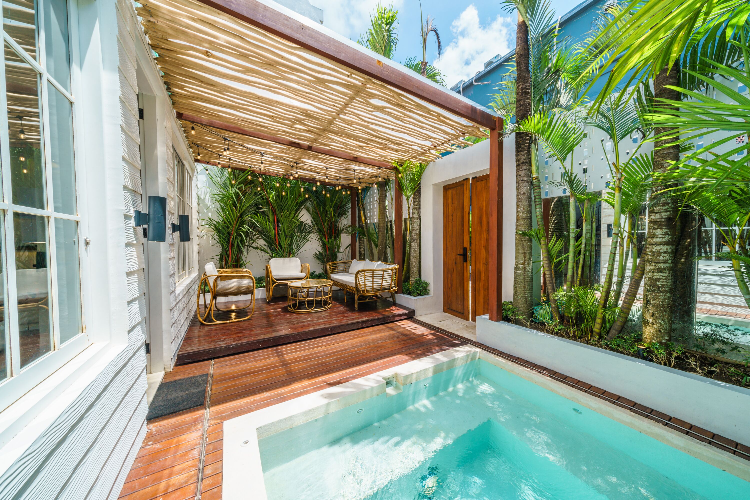 A poolside area with a wooden deck, outdoor seating, and a pool.